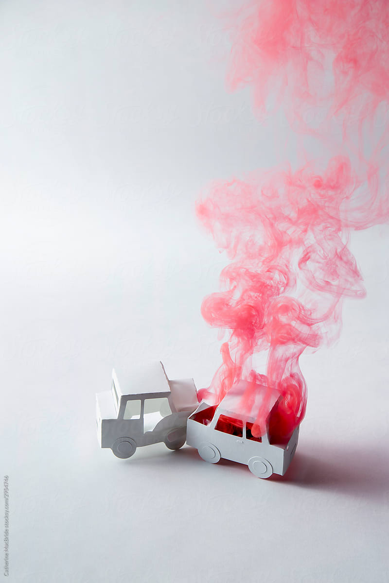 Two crashed paper-craft cars one is billowing red smoke