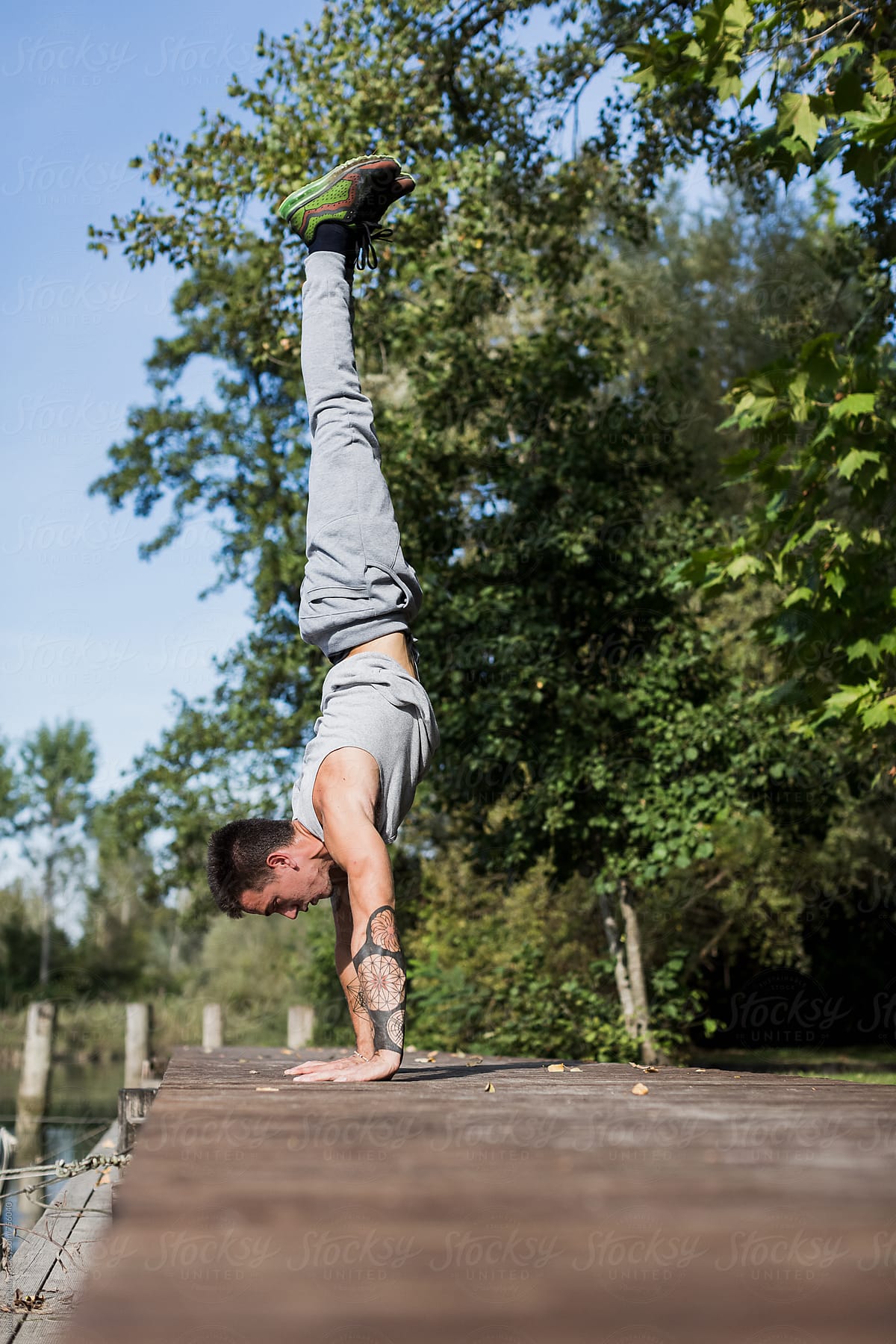 Fit Man doing Handstand pose in a jetty