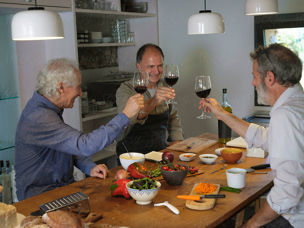 Men toasting wine while cooking dinner