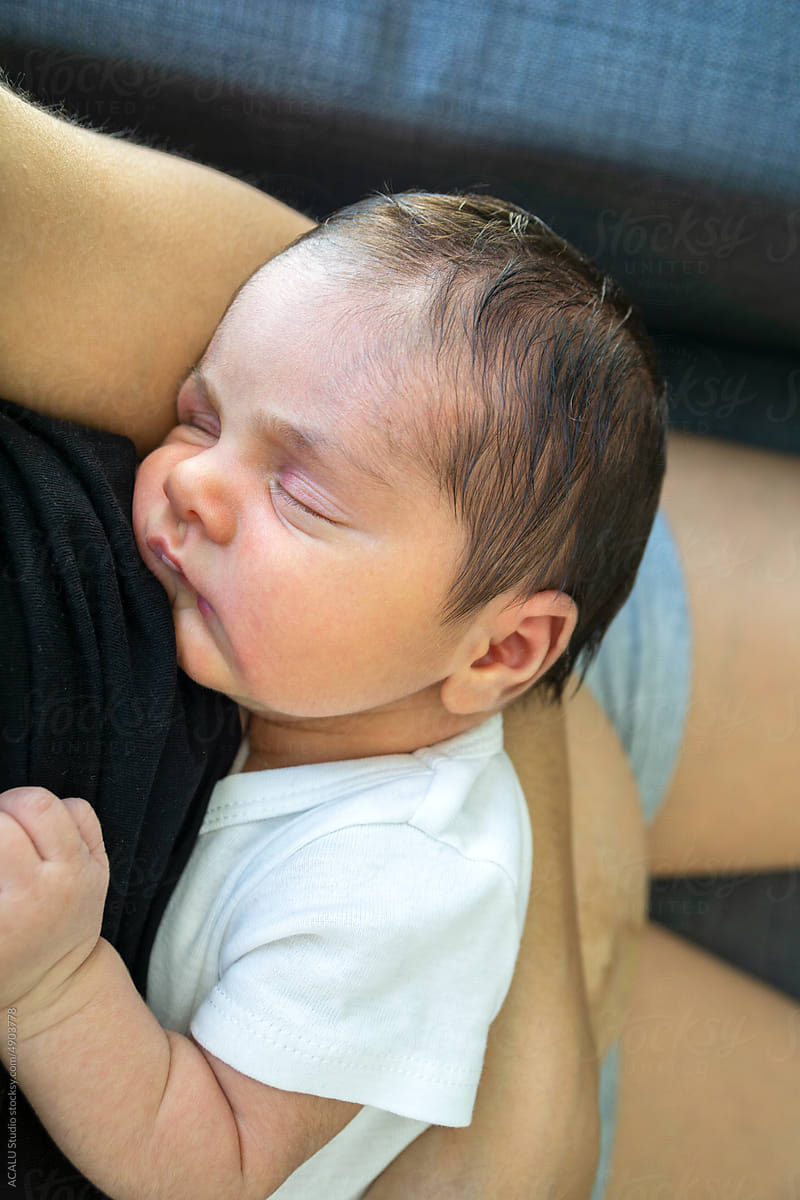 Sleeping newborn baby in mom\'s arms
