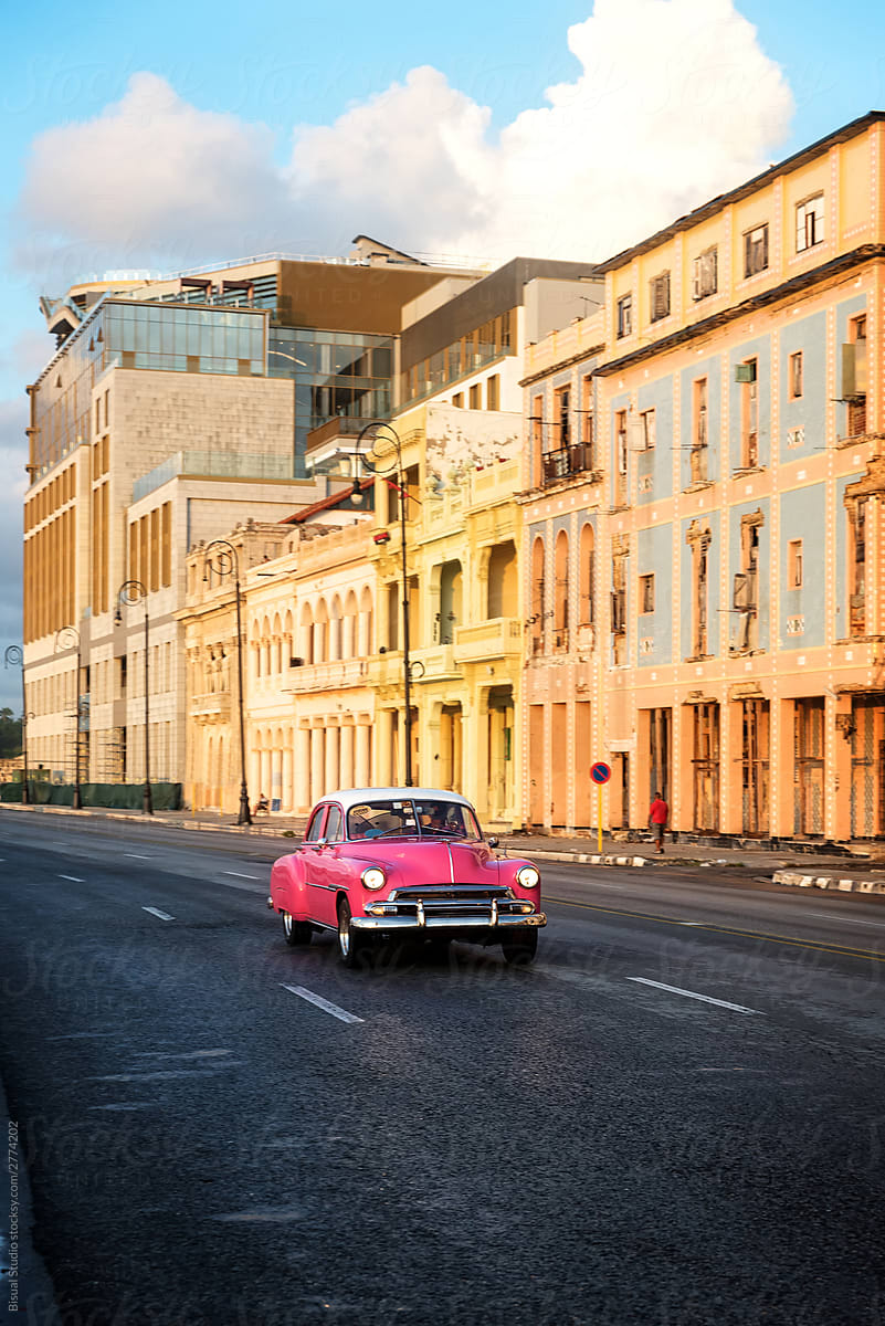 Vintage pink car driving through El Malecon in La Havana, Cuba