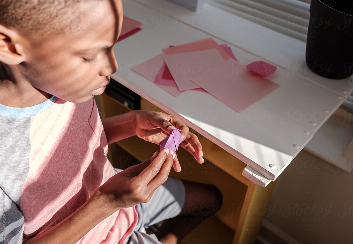 Young boy making heart Origami