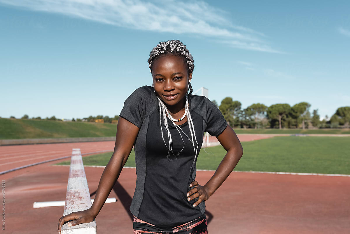 Positive African American sportswoman near barrier