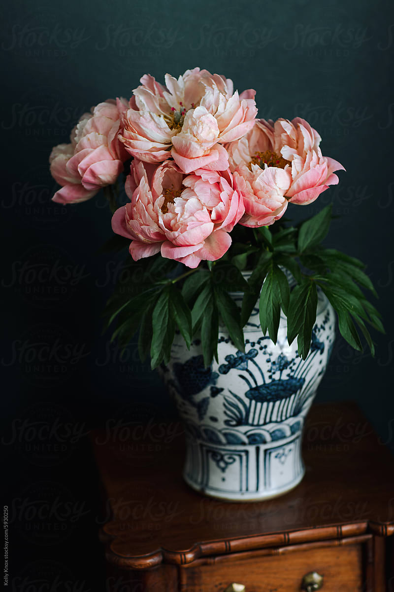 coral charm peony blooms in a large vase