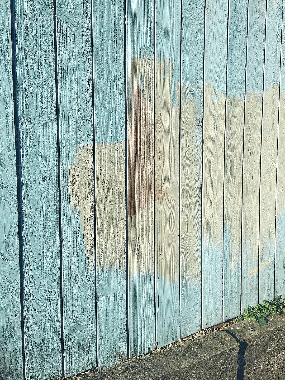 Paint covering graffiti markings on urban fence