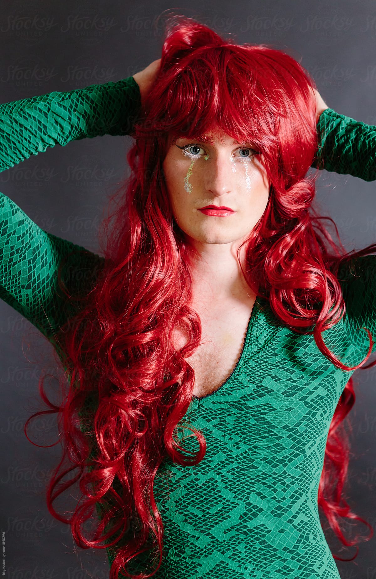 Non Binary Guy In Drag Wearing Green Dress And Red Wig By Stocksy