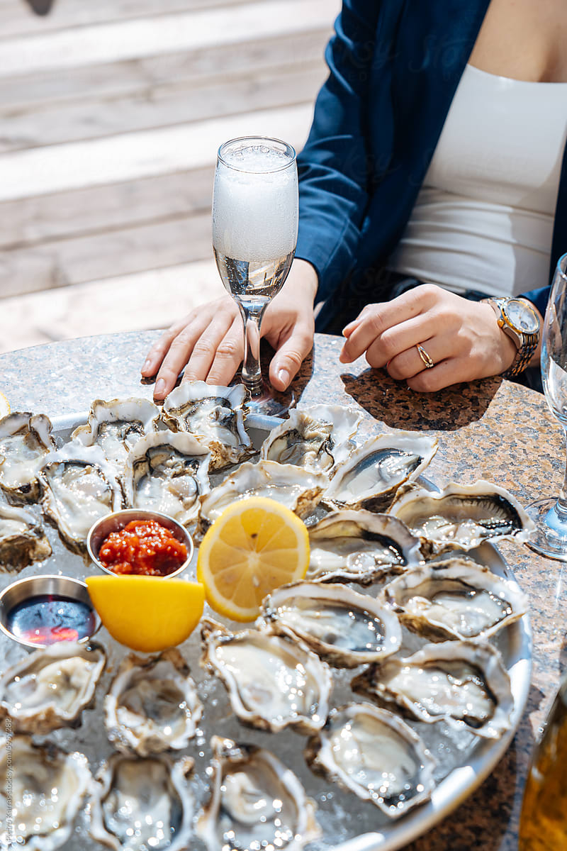 person with glass of champagne over Plate of Oysters