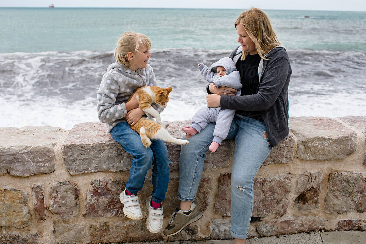 Family and stray cat on the sea embankment