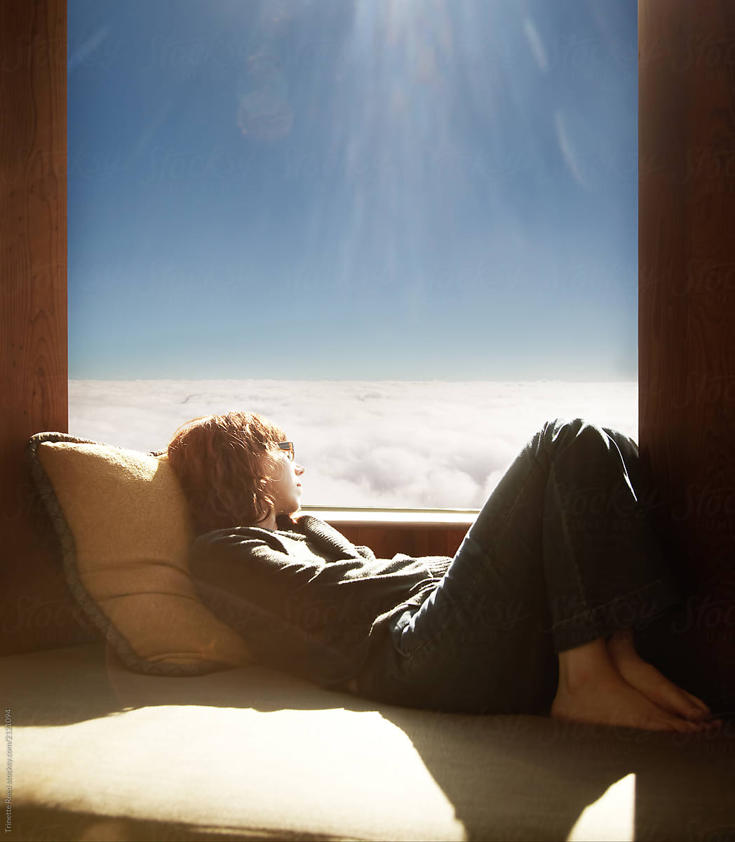 Woman relaxing in cabin on mountain above the fog/ clouds in California