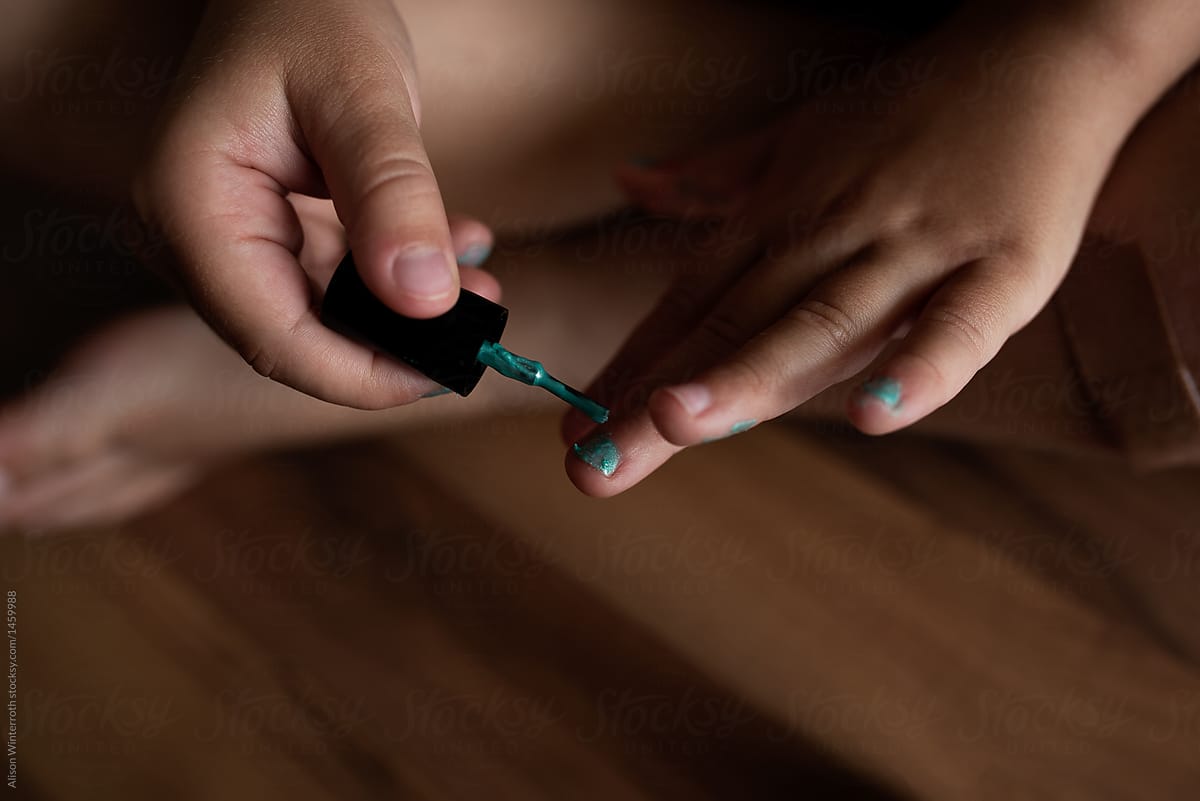 A Child Painting Her Nails Green