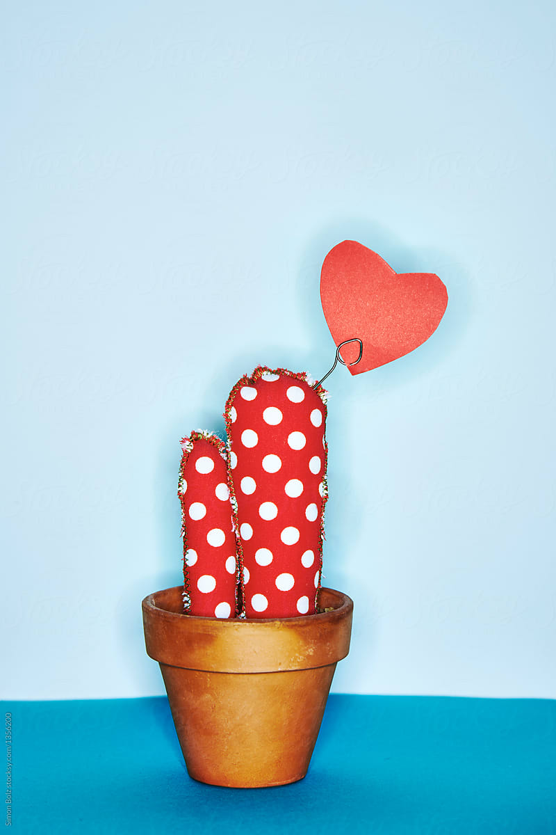 Red fabric cactus with white dots in front of a blue backdrop