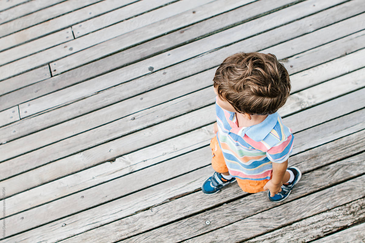 Bird S Eye View Of A Young Boy Walking On A Wooden Boardwalk By