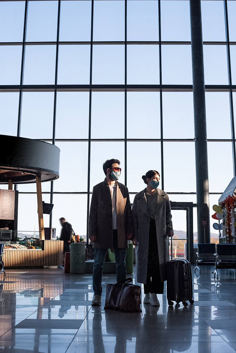 Couple against airport window during pandemic