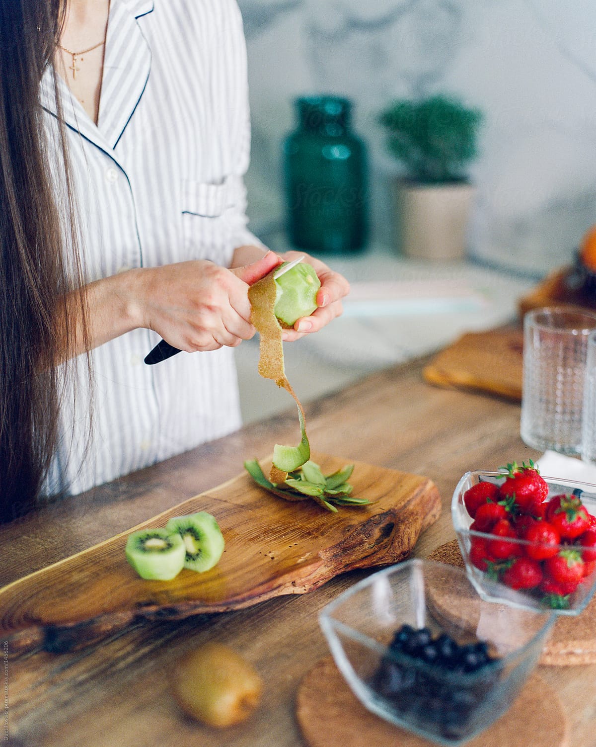 Woman peeling kiwifruit