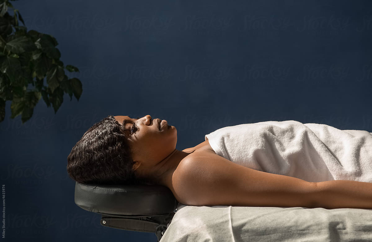 Calm black woman on massage table
