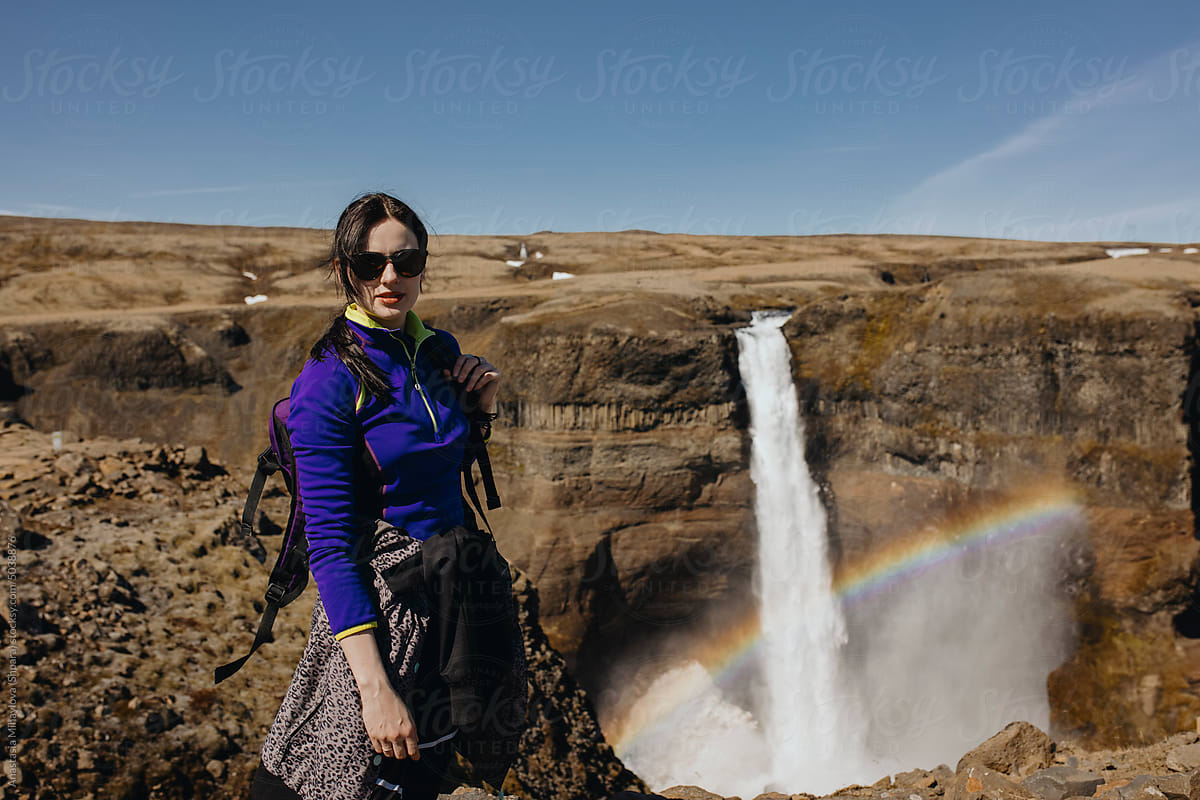 Traveler woman looking on A Huge Waterfall In Iceland with rainbow