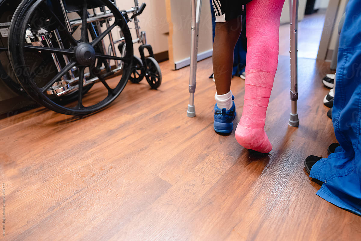Close view of child on crutches with pink cast