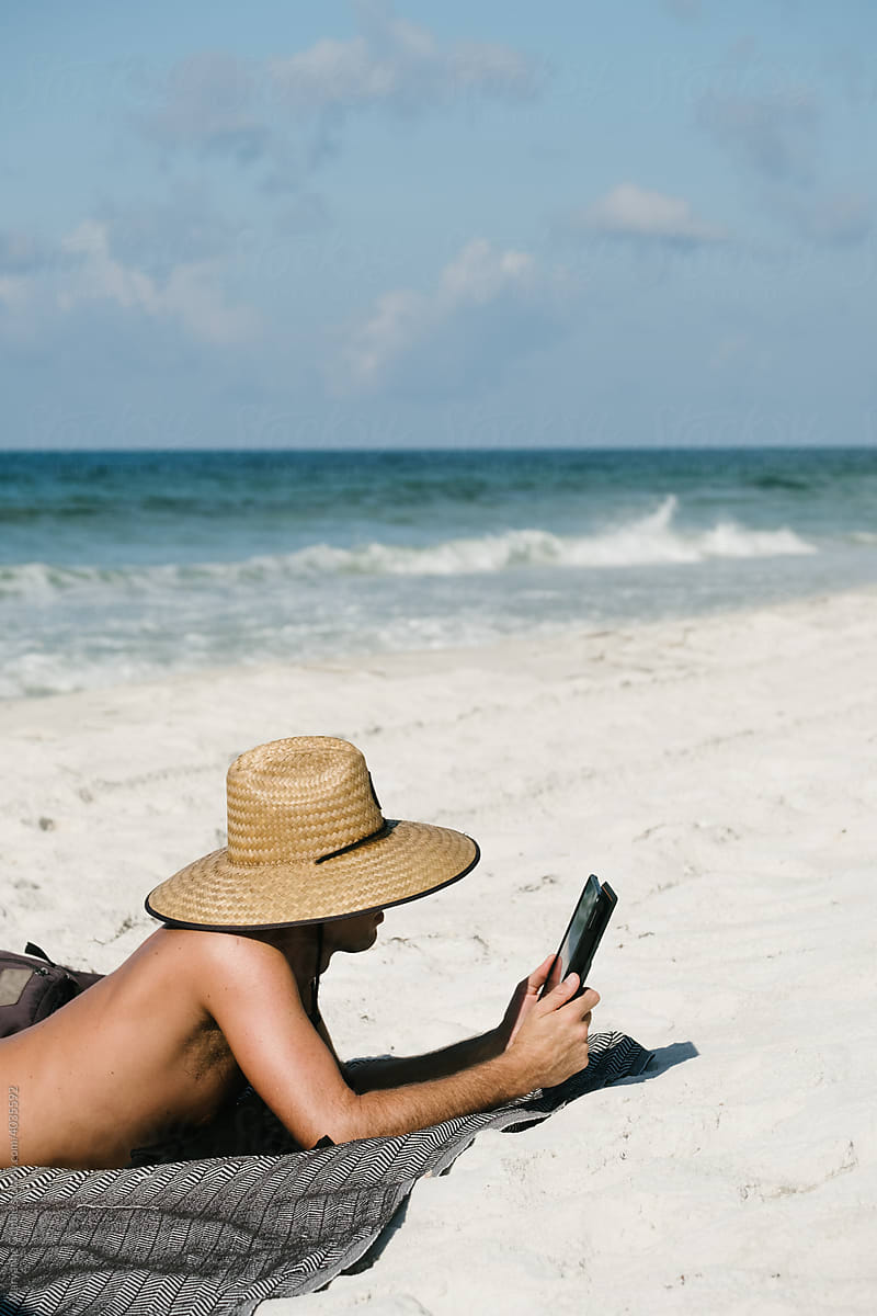 Man Reading on his Mobile Device at the Beach.