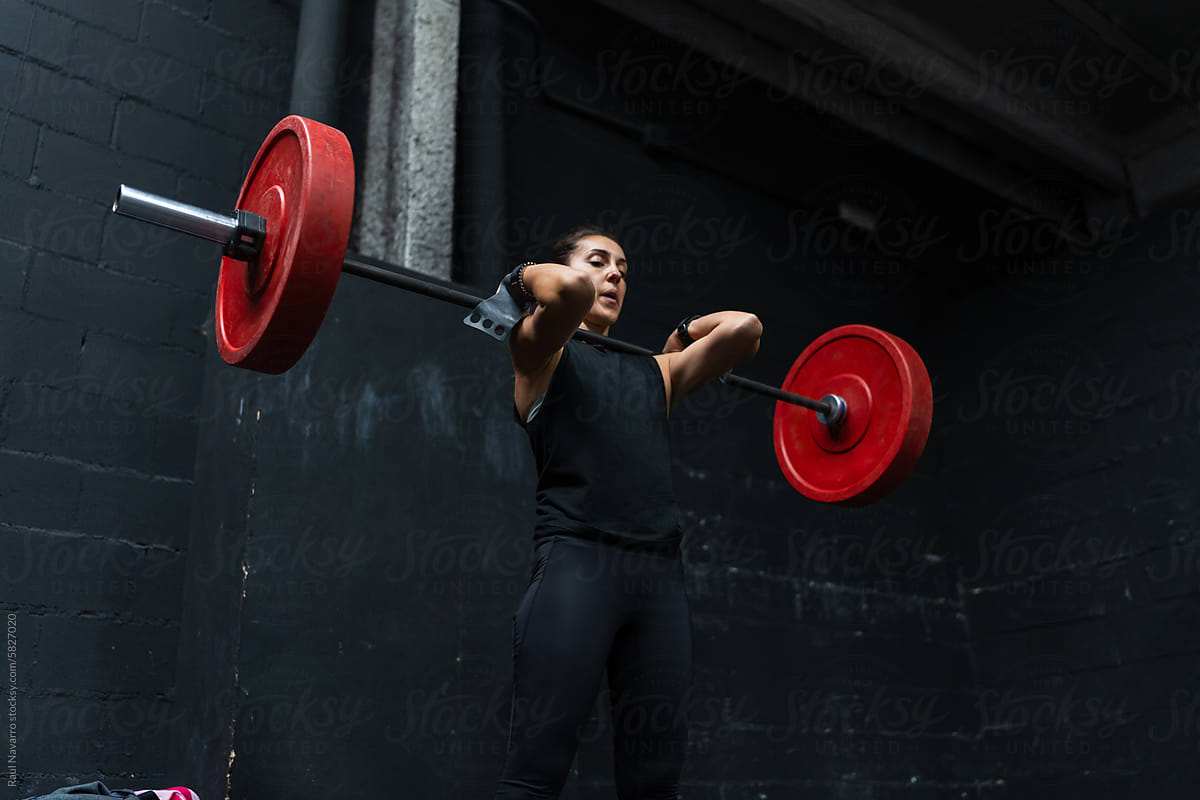 Athletic woman lifting a barbell at the gym