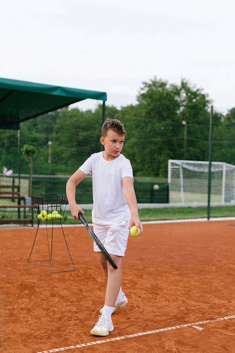 Young boy playing tennis on the tennis court