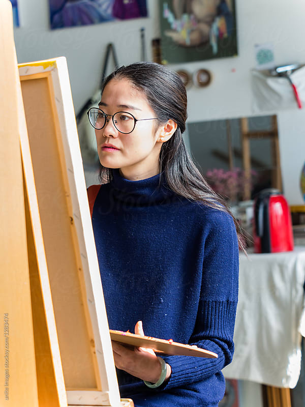 front view of a female artist painting in art studio