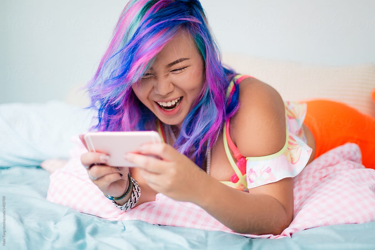 Beautiful plus size woman with multicolor dyed hair in pastel bedroom