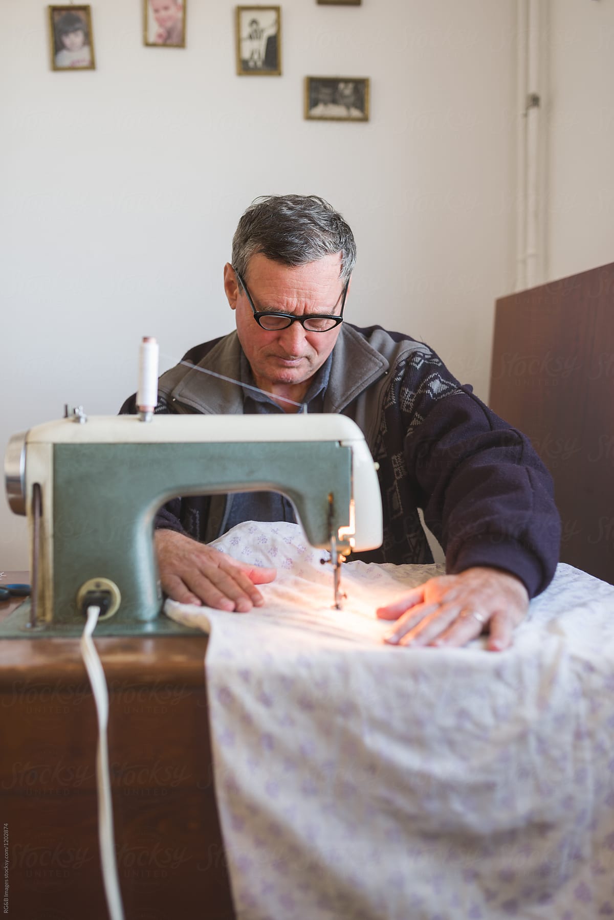 Male around 60s tailoring a piece of fabric indoor