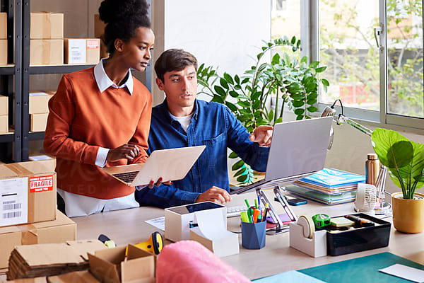 Young Logistic Manager Organizing Boxes In Storage by Stocksy