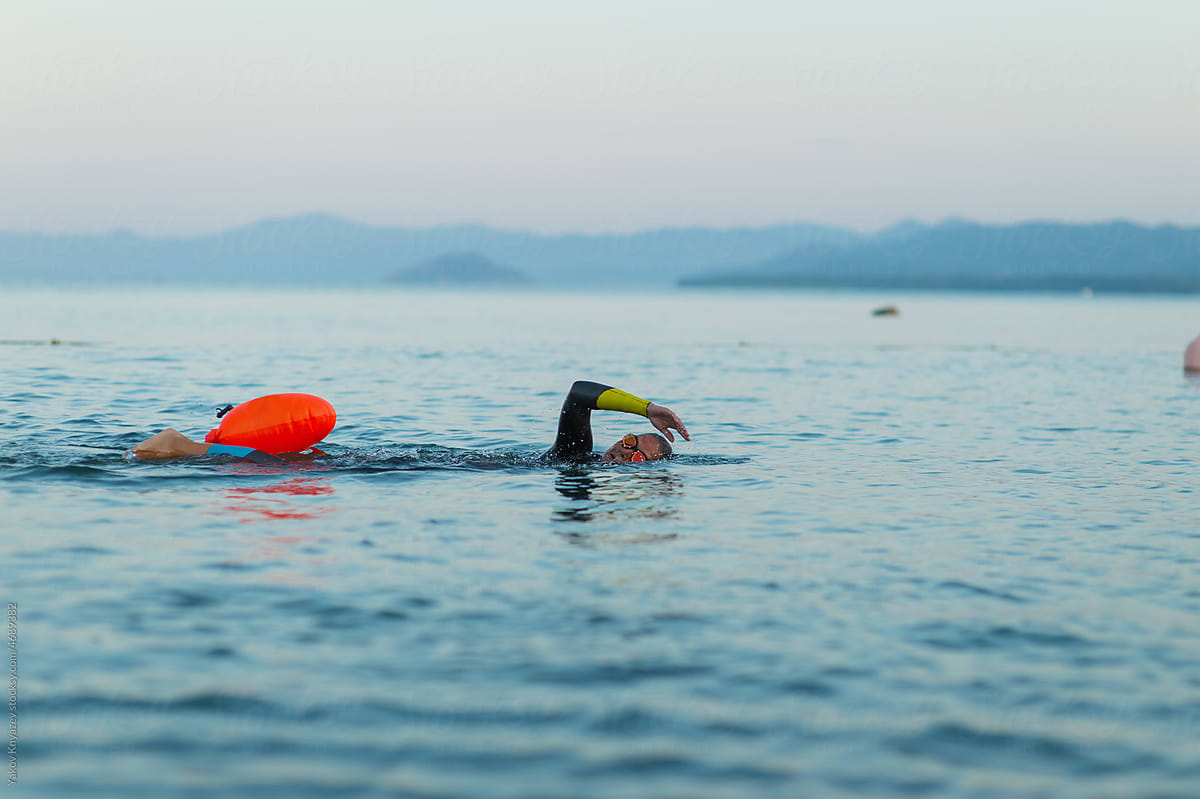 open water workout of a female swimmer using safety buoy