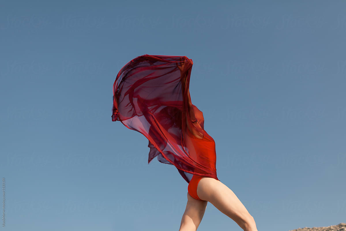woman covered with red fabric running