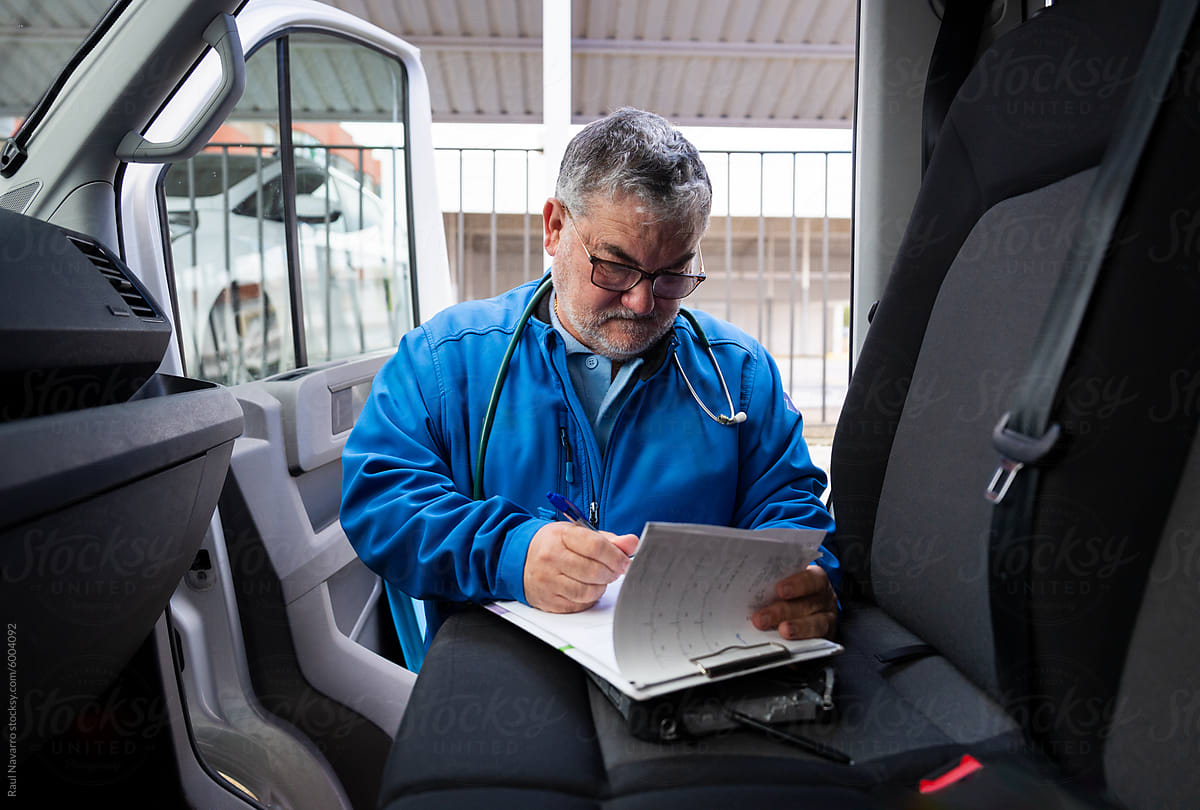 Paramedic filling out a doctor\'s report in an ambulance