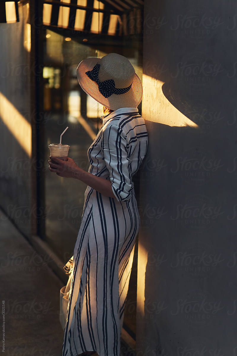 Relaxed stylish woman with coffee standing next to building