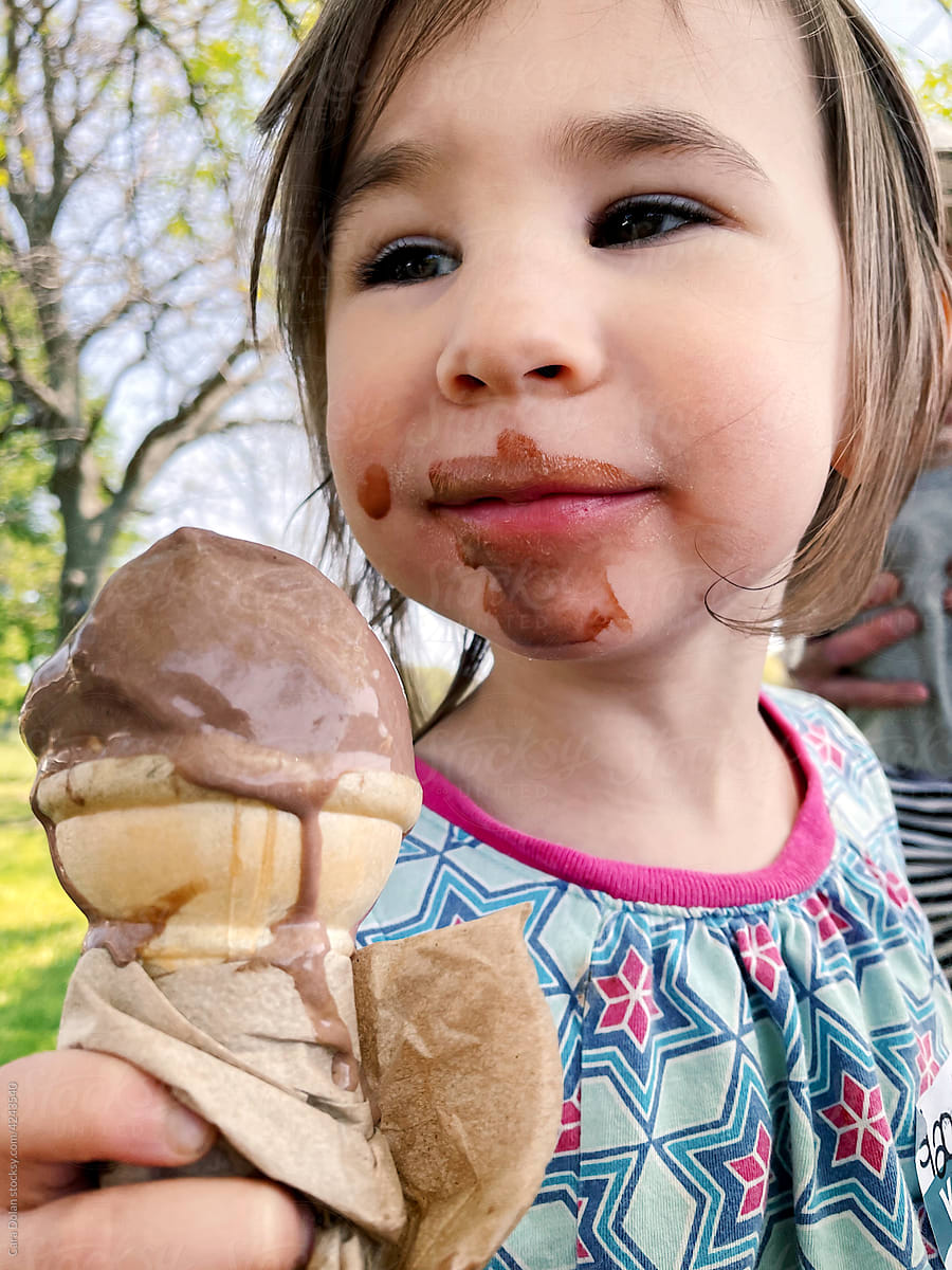 Happy Little Girl Eating a Chocolate Ice Cream Cone