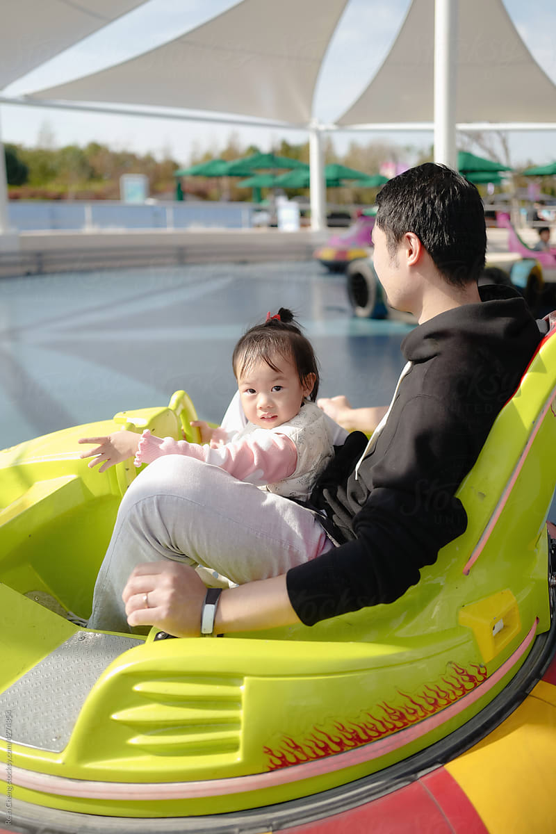 Asian baby and dad drive bumper car