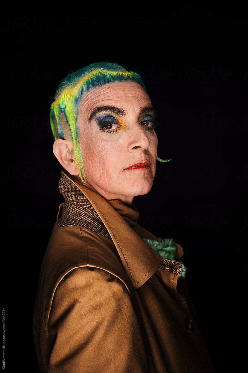 Extravagant senior woman with bright makeup and hair tattoo