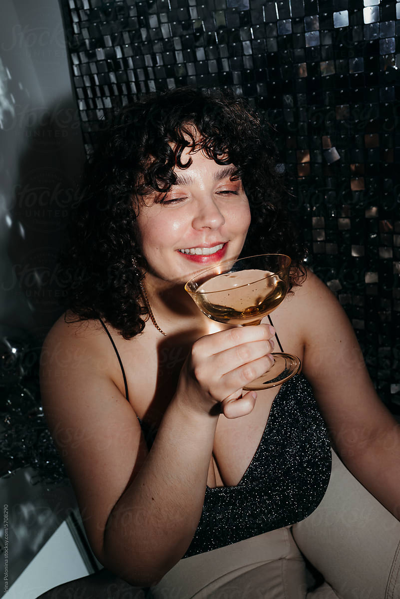 Girl with glass of drink at party.
