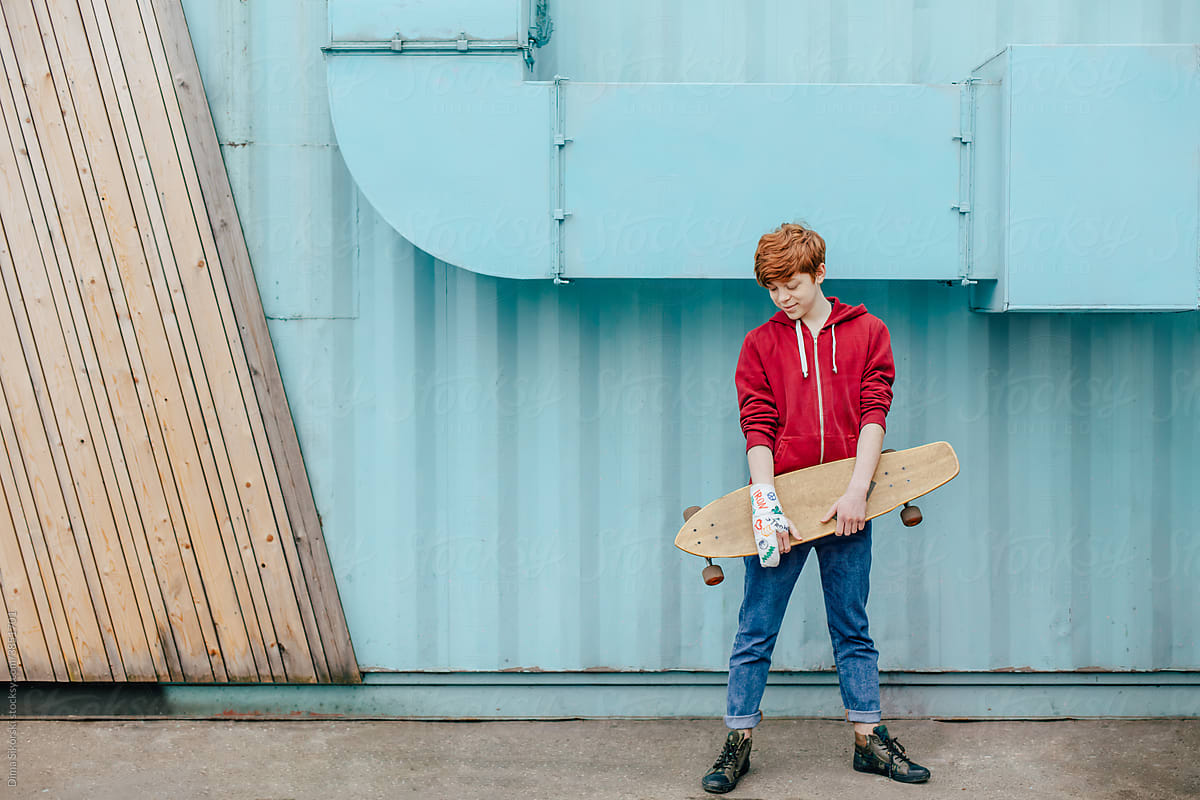 portrait of a teenager with a fracture and a skateboard