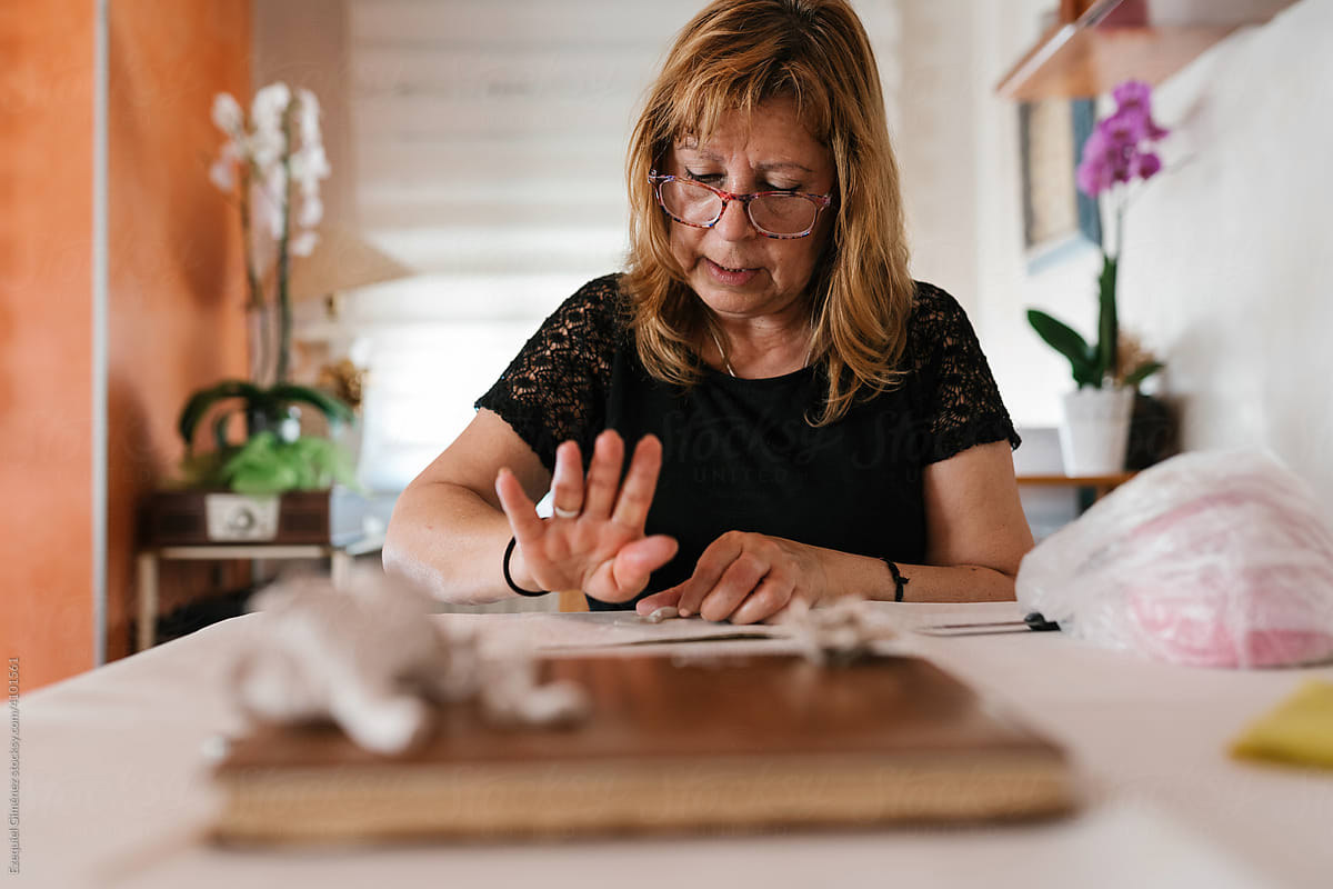 Concentrated adult craftswoman working with porcelain