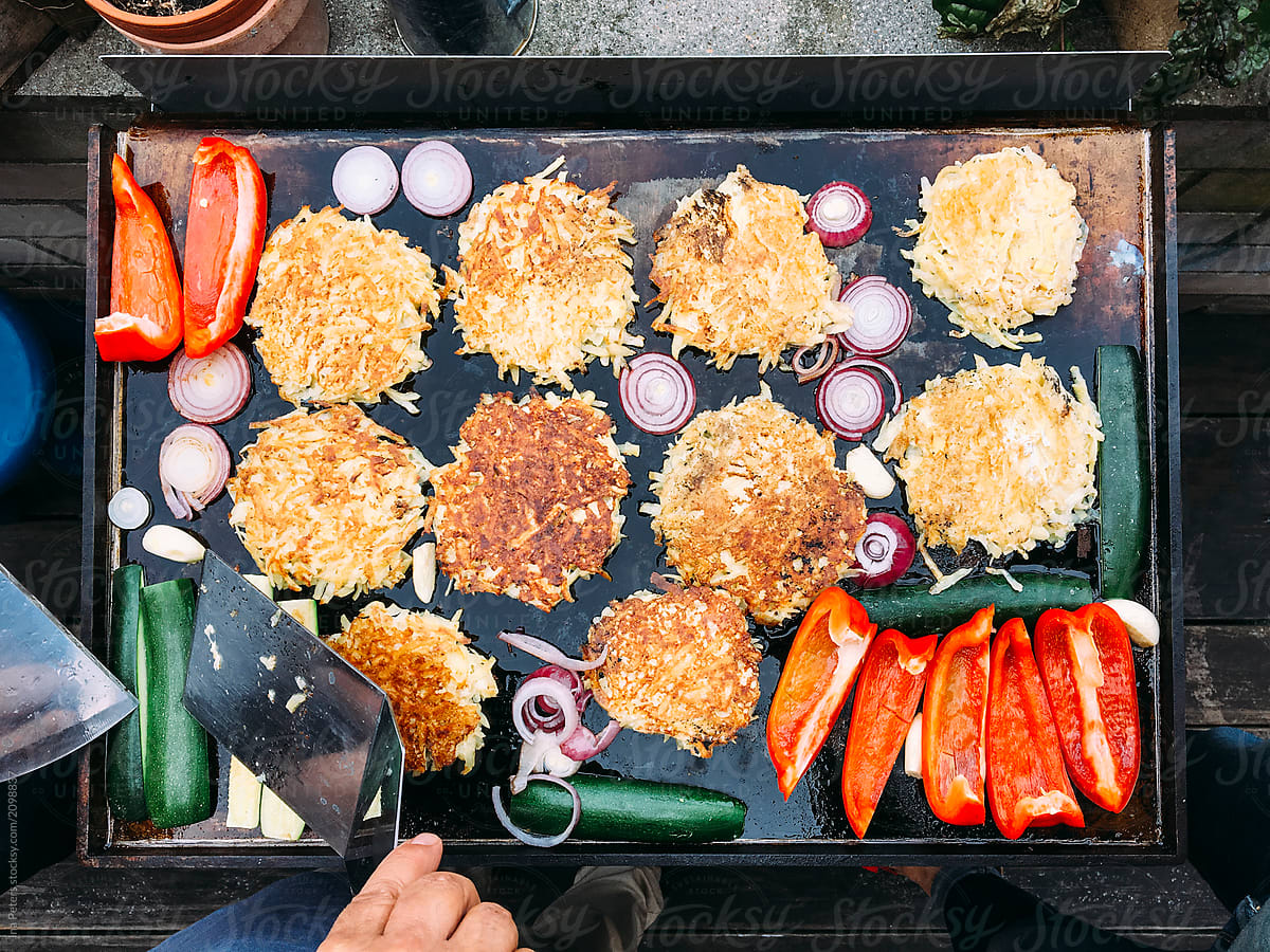 Food: Zucchini potato pancakes and vegetables on a plancha grill