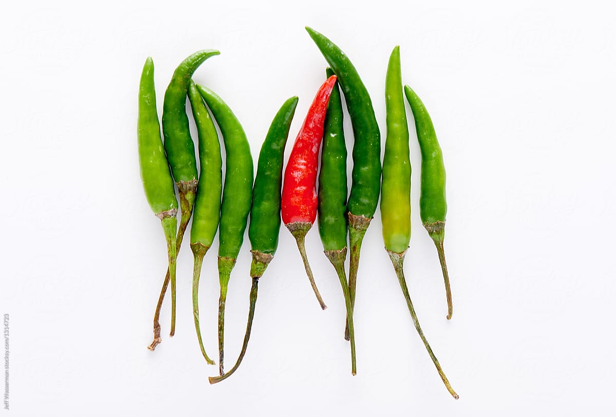 Arrangement of Green and One Red Chilli Peppers