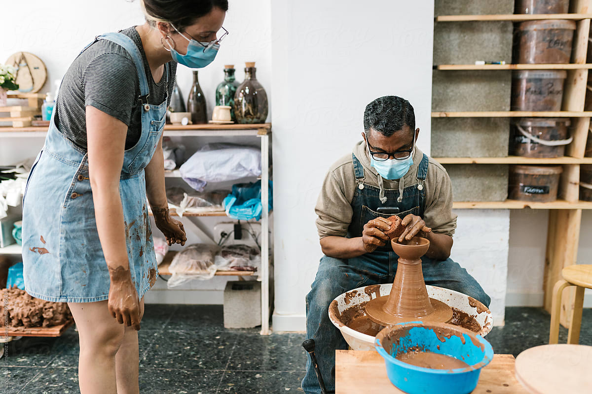 Artisan teaching pottery to his student