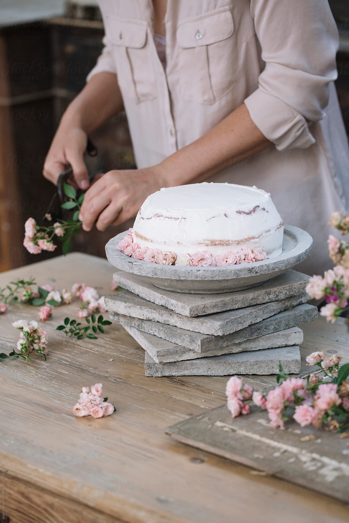 Person cutting flowers for cake
