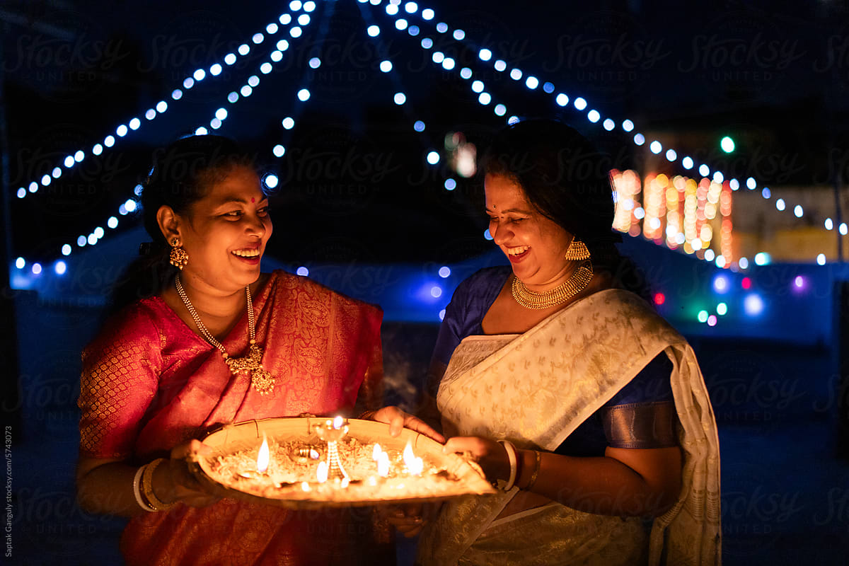 Happy women celebrating diwali with oil lamps