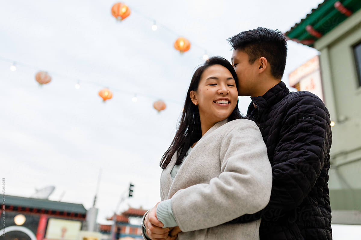 Happy Asian Couple Hold Each Other While on a Date