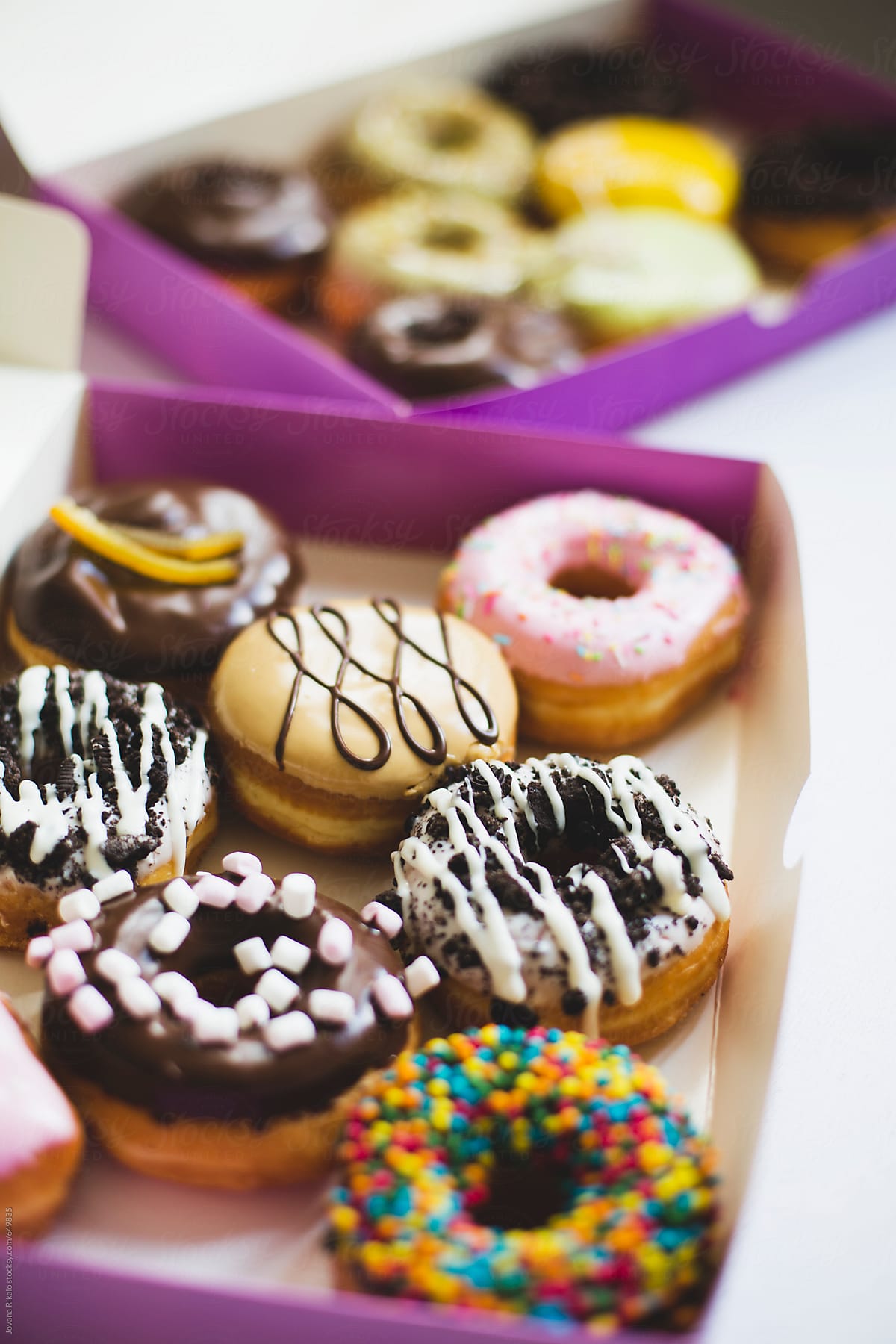 Colorful donuts in a takeaway box