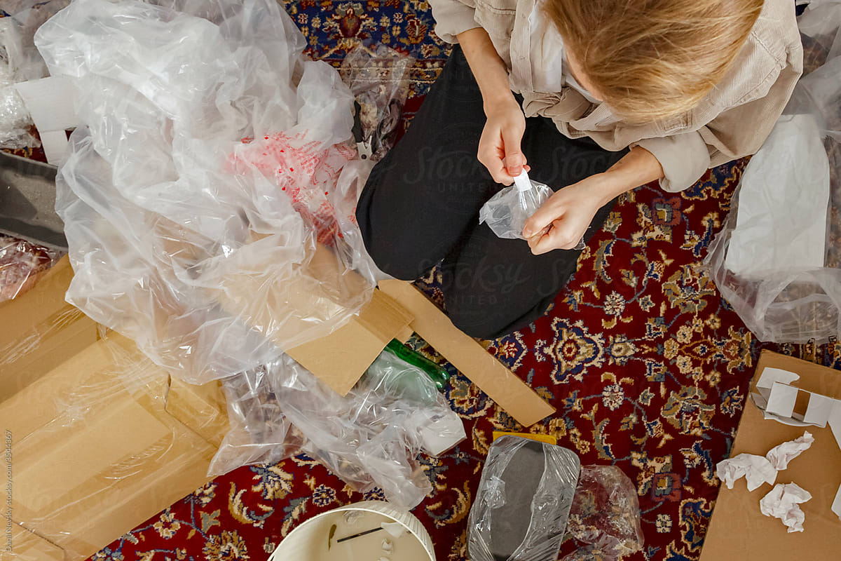 Anonymous woman removing label from recyclable packaging