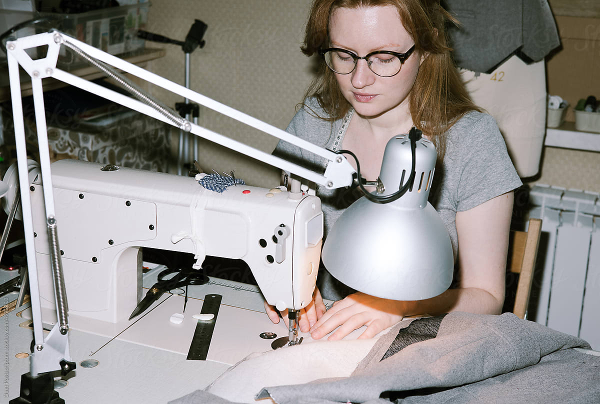 Young woman sewing at a sewing machine