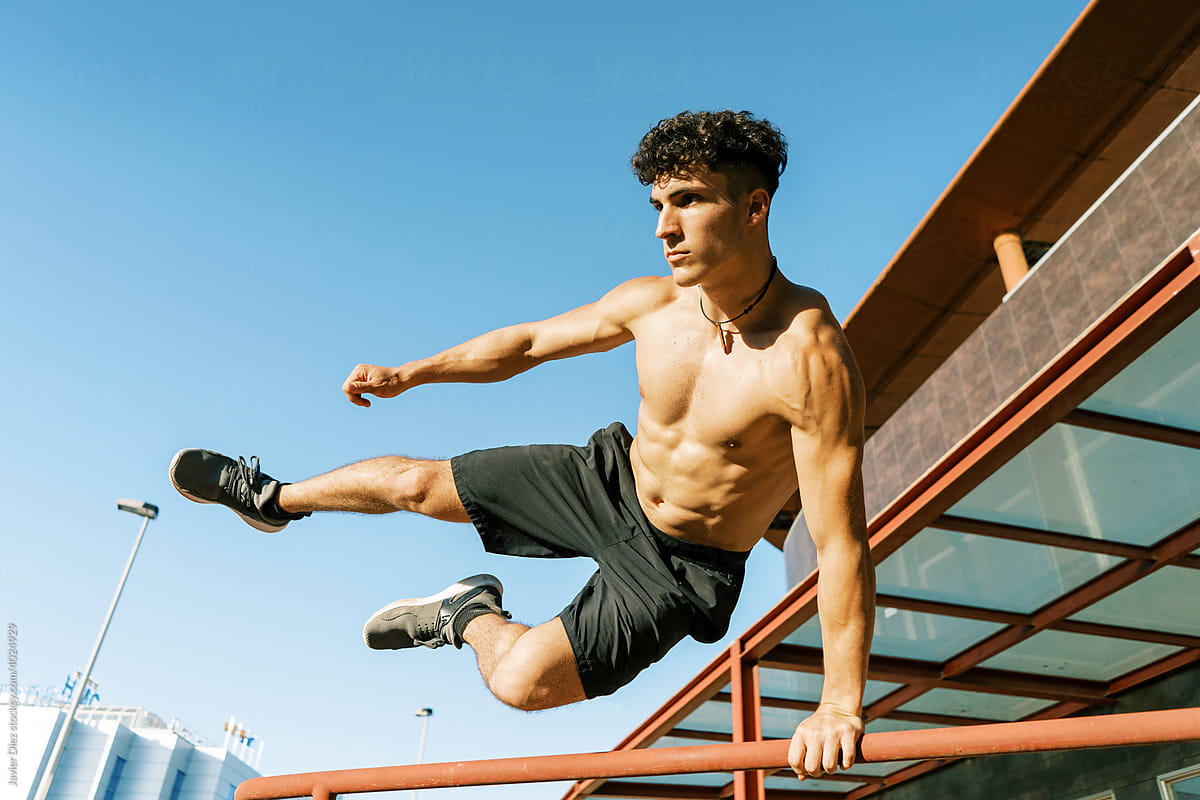 Muscular man jumping over obstacle