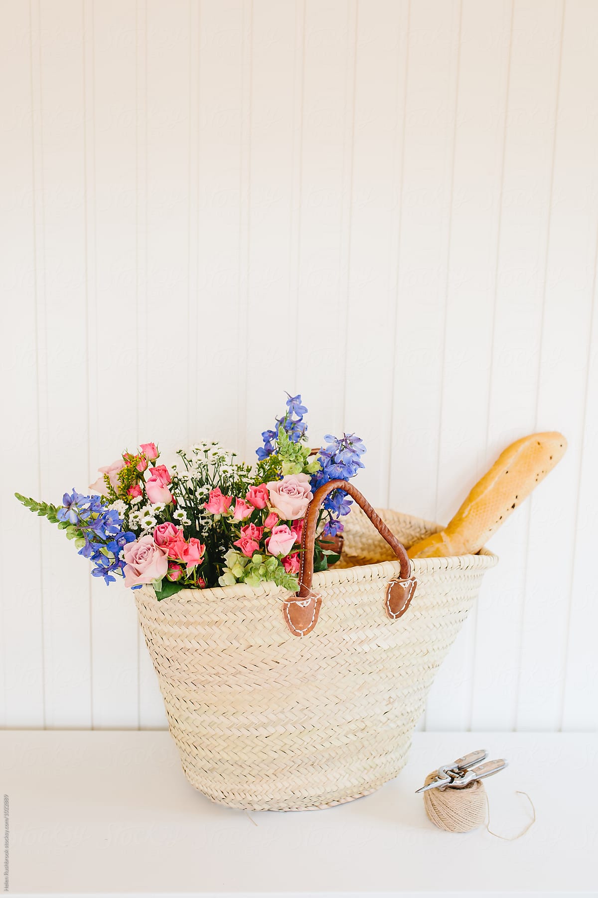 Summer flowers and a baguette in a french market basket