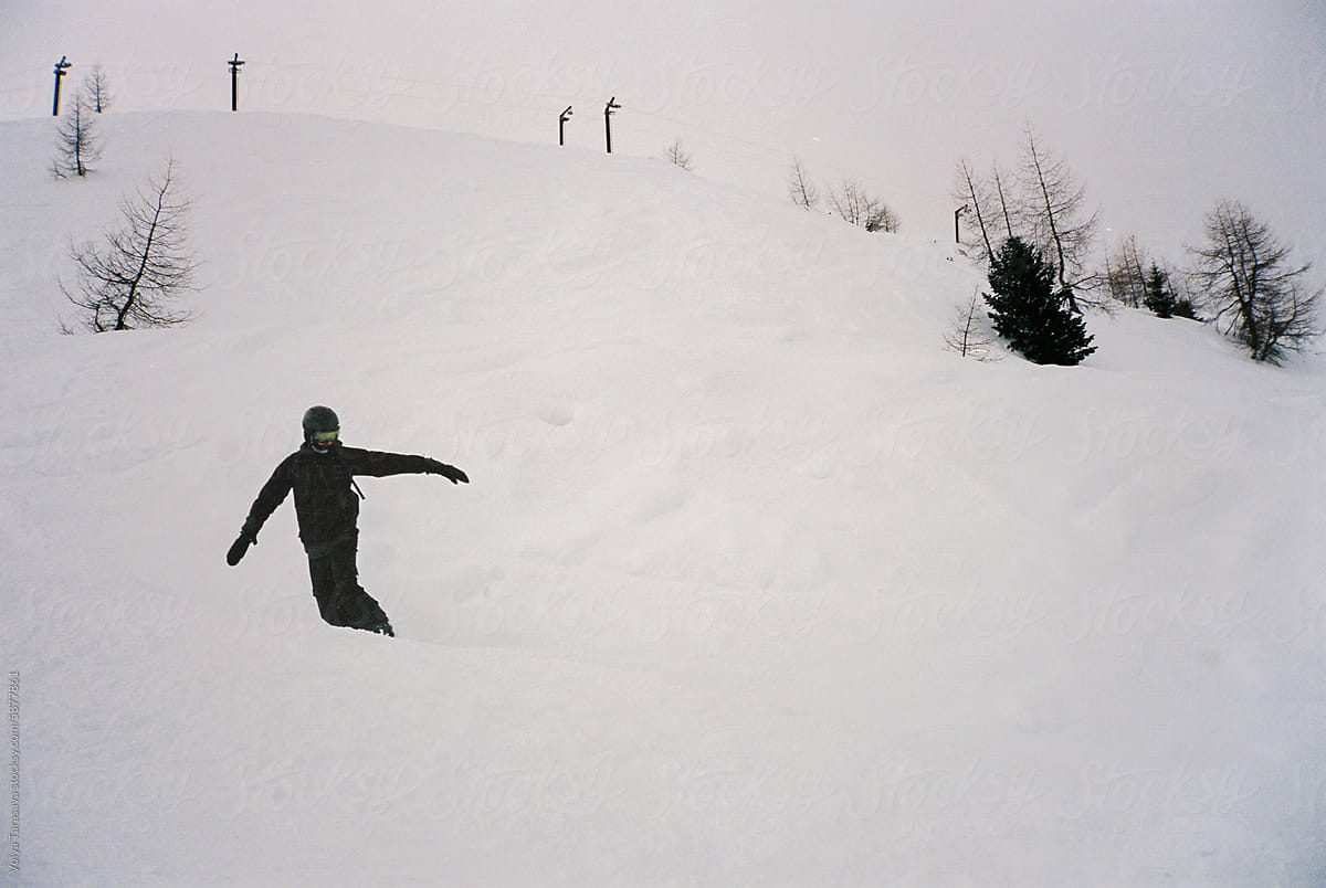 Young man snowboarding in the snowy mountains